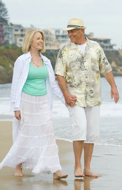 White peasant skirt worn by mature woman walking on the beach with her husband.