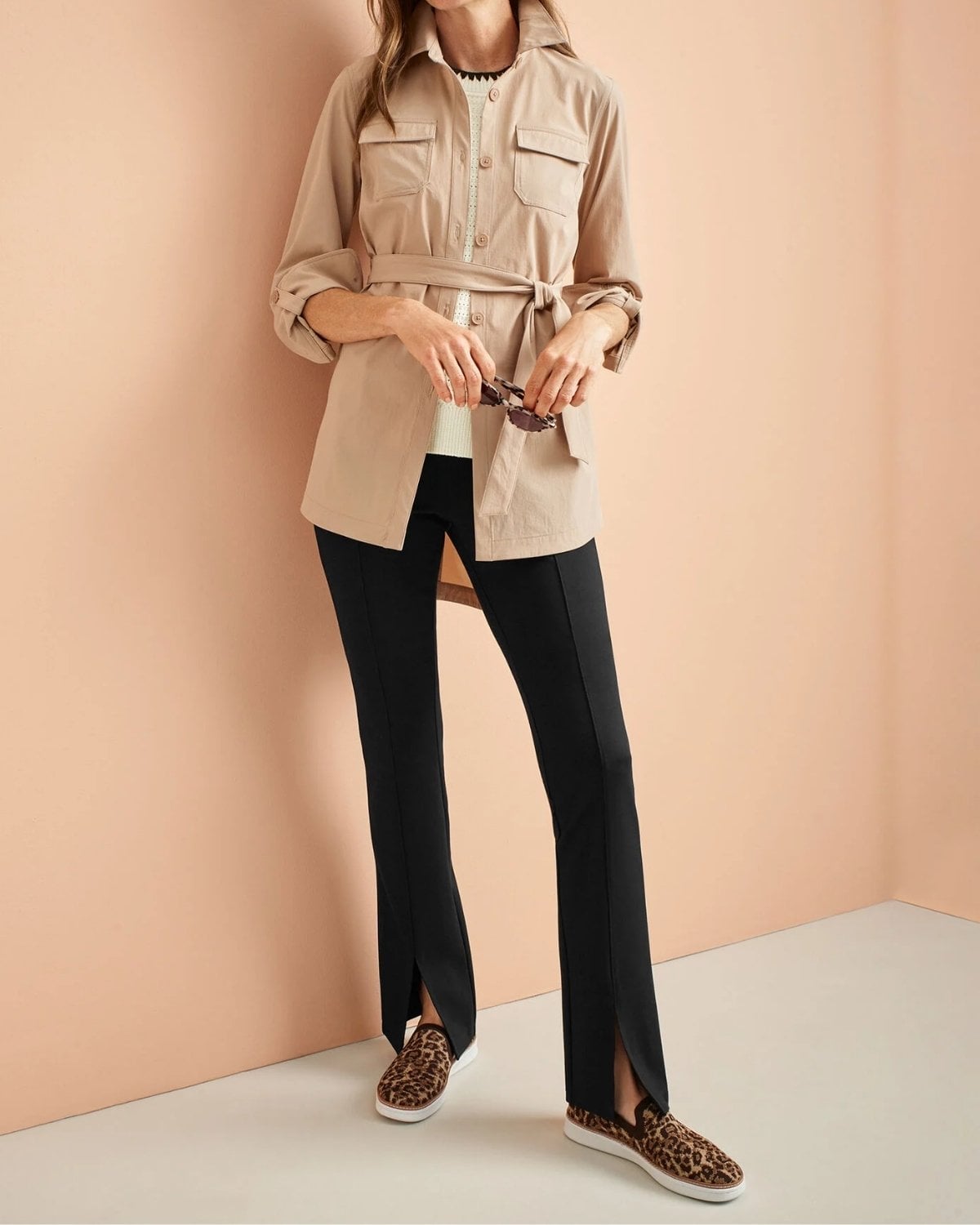 Beige utility jacket with black pants and leopard slip-on sneakers for a comfortable New York City sightseeing outfit.