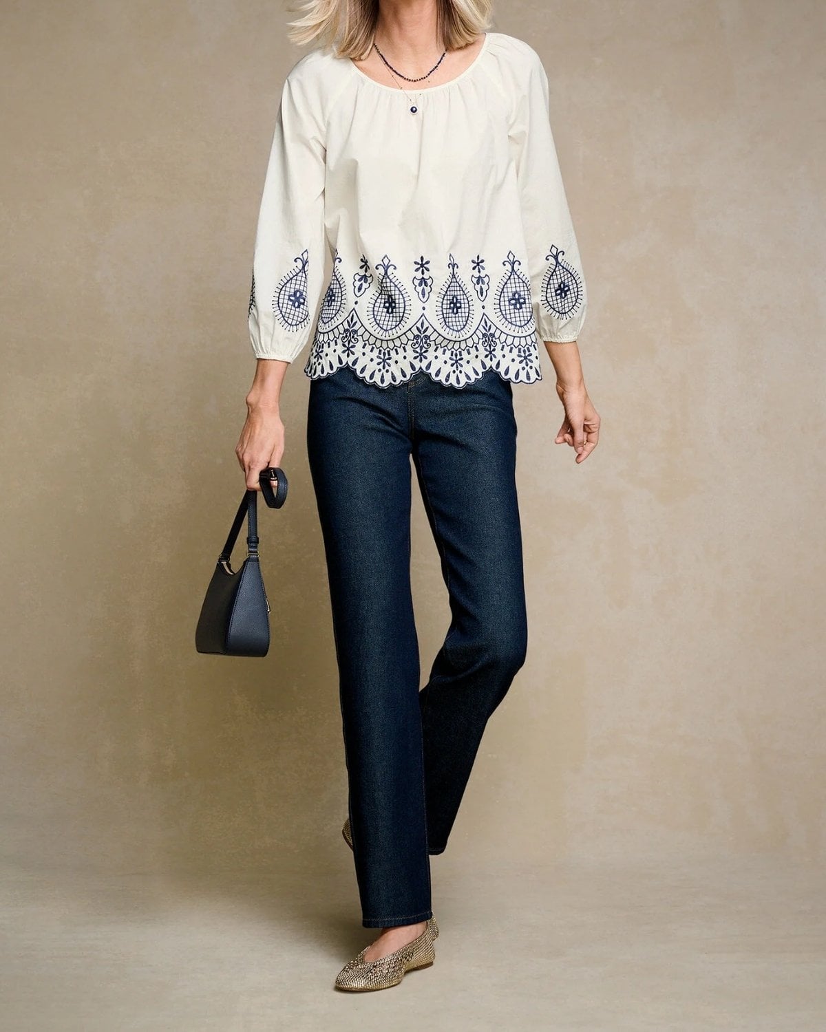 White embroidered blouse with dark straight-leg jeans and woven flats for a casual New York City outfit.