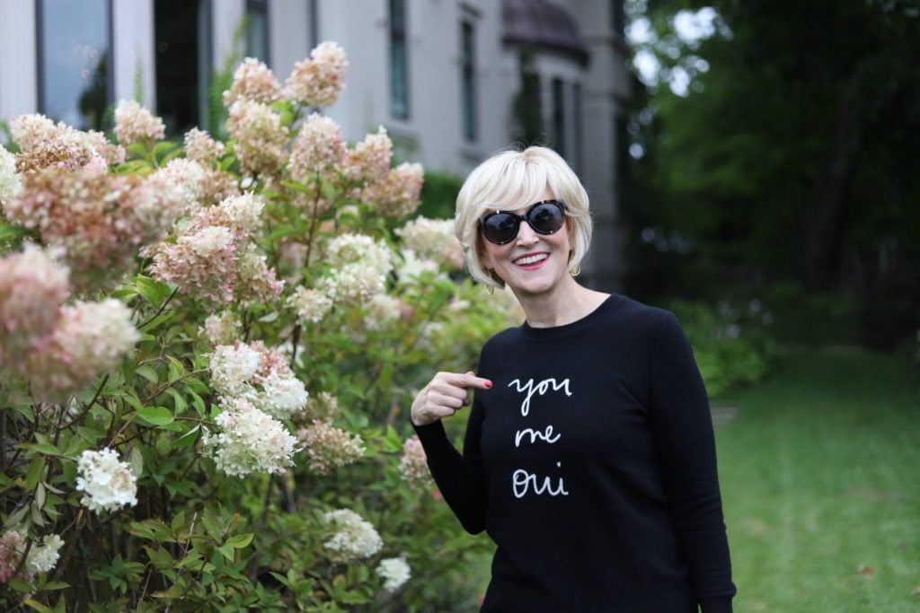 laughing at statement sweater