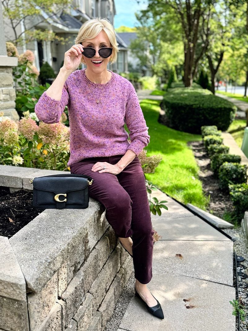 purple pinwale corduroy pants, purple tweed crew neck sweater, coach black bag worn by Deborah Boland - Fabulous After 40