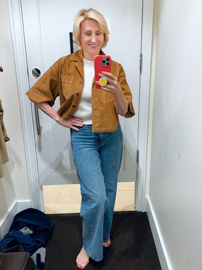 WOMAN STYLING AN OUTFIT WITH WIDE LEG JEANS AND TUCKED IN TOP WITH CROPPED JACKET