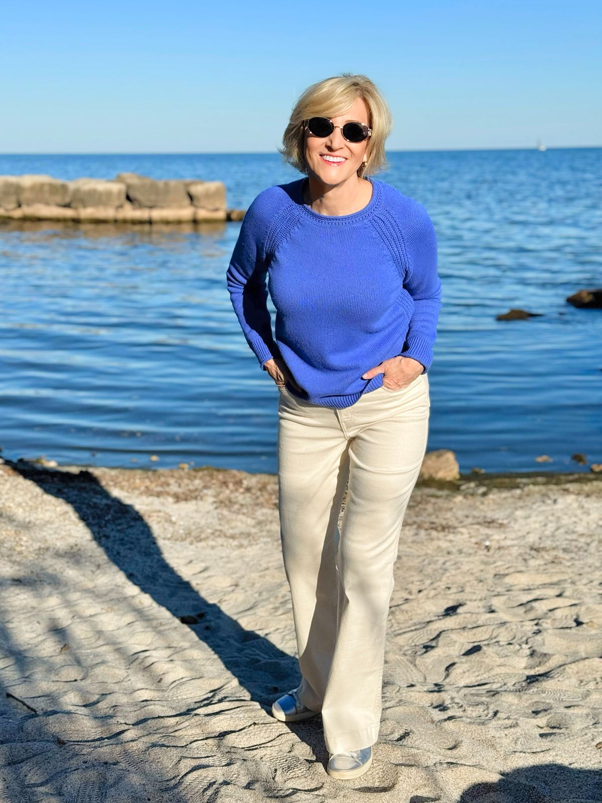 fall outfit ideas with white jeans women 40+ , colorful cotton sweater and natural pants