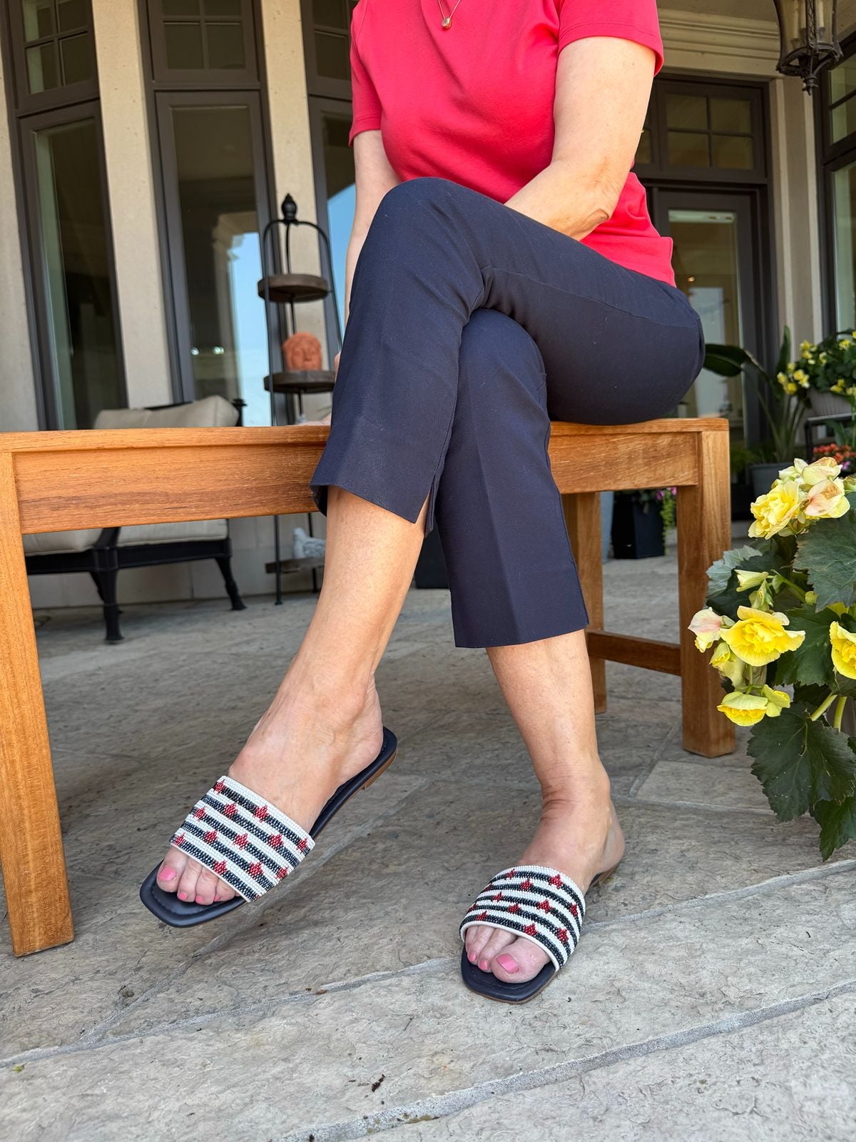 Striped slide sandals worn with navy capris