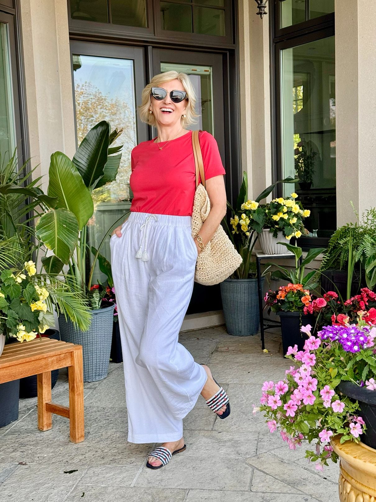 Deborah Boland in white wide-leg pants and a red tee showing a comfortable summer outfit instead of shorts