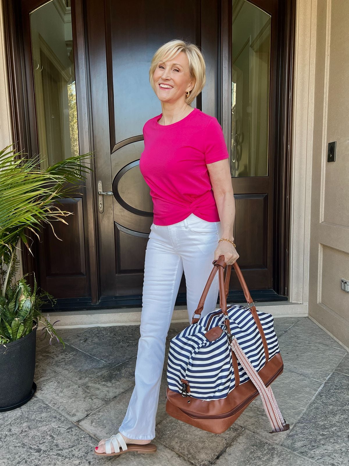 Deborah Boland carrying a navy striped weekender bag, a classic travel bag for women and weekend trips.