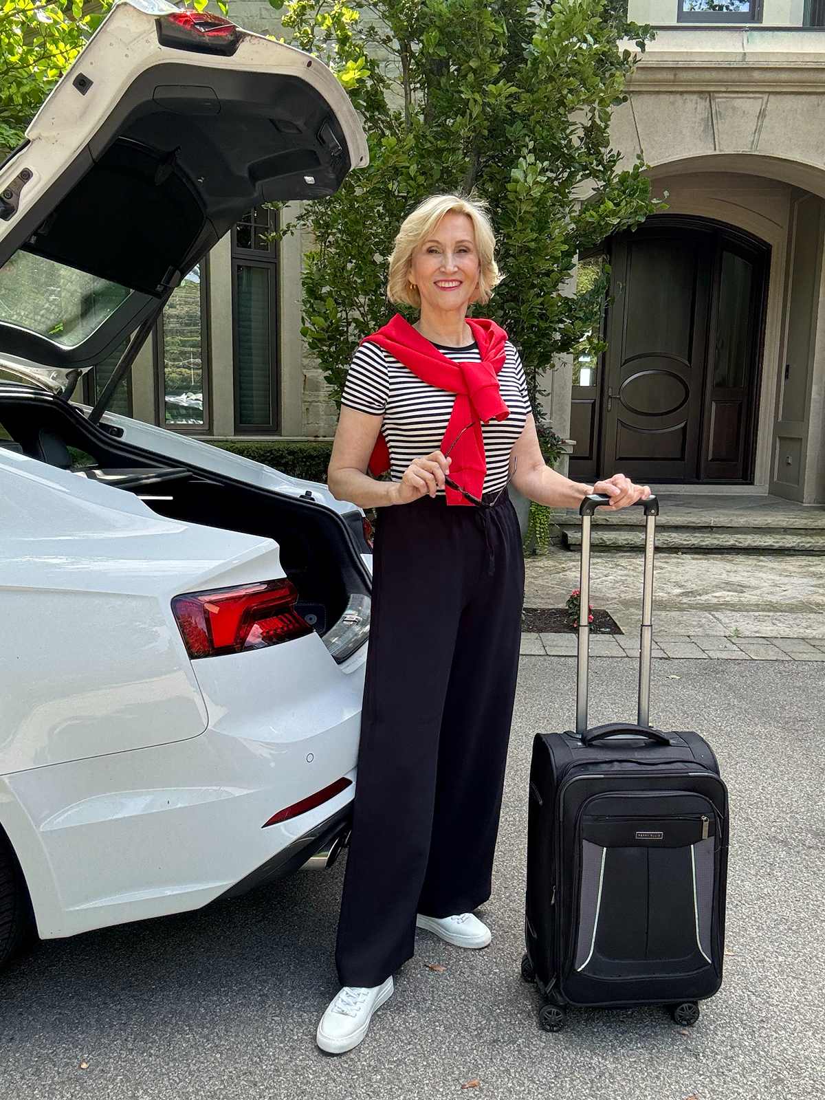 Deborah standing with her suitcase 