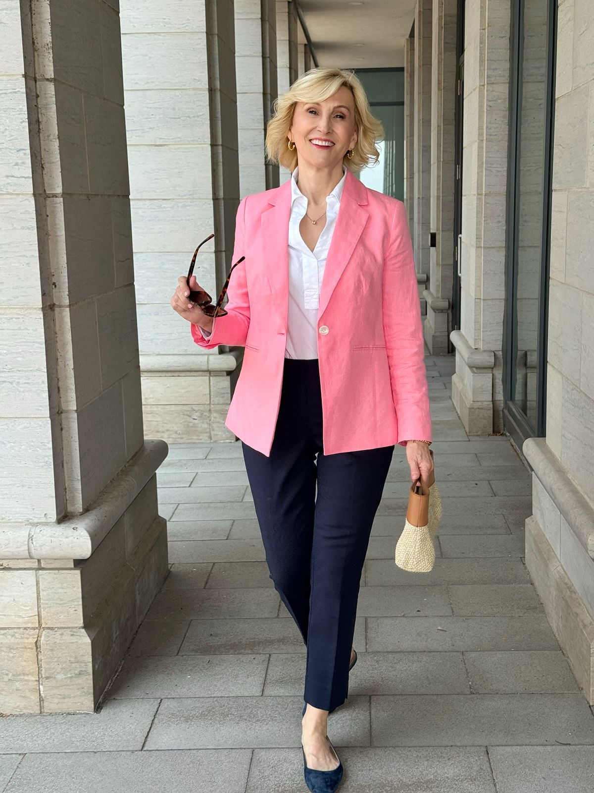 Deborah Boland styling a white shirt with a pink blazer and navy pants