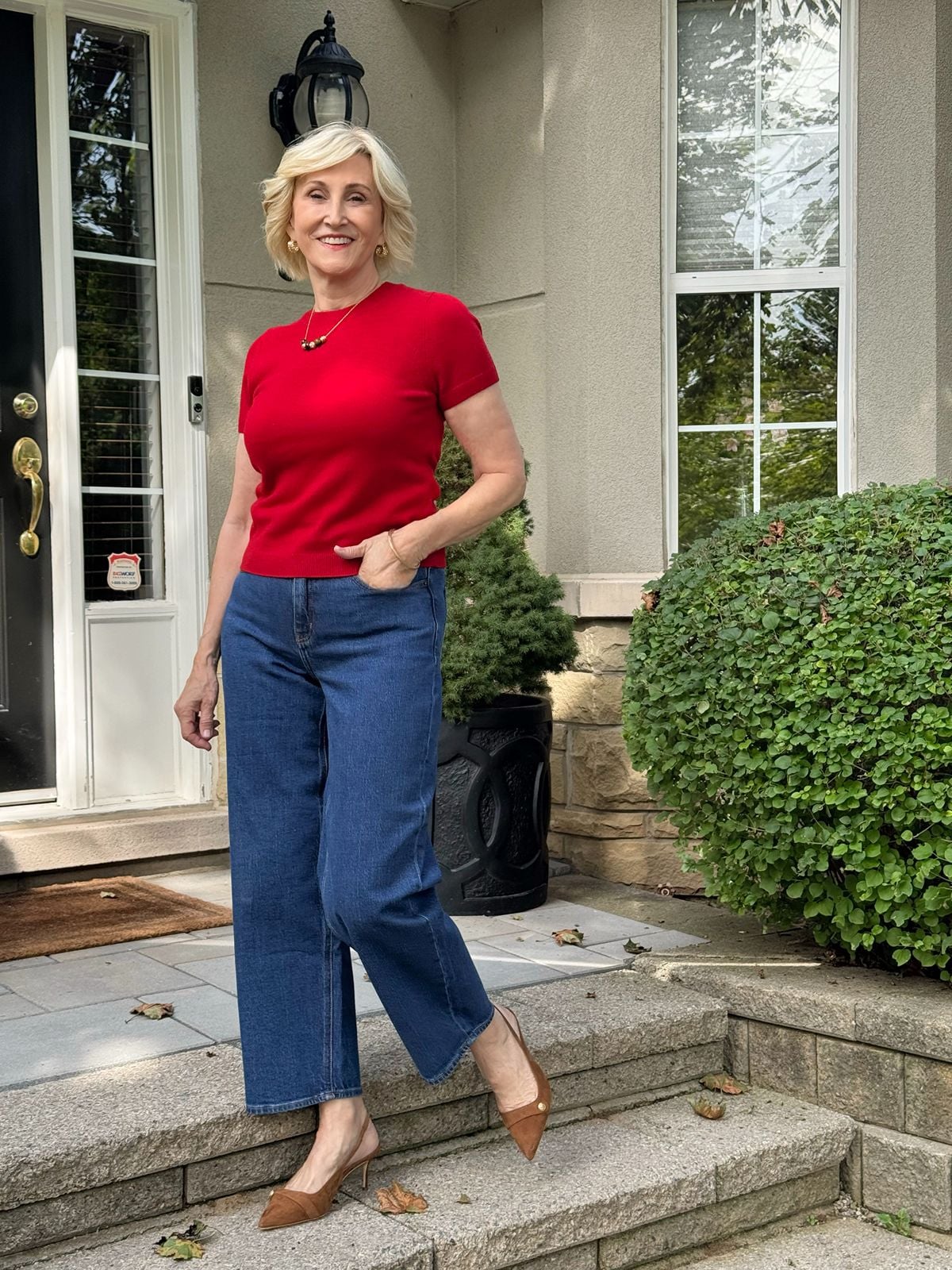 Dark wash barrel jeans outfit for women over 50 with a red sweater and brown slingback heels